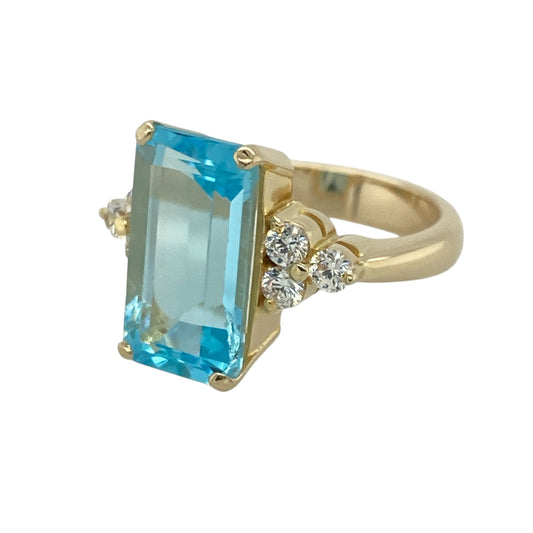 Make a bold and elegant statement with this pre-owned 14ct yellow gold blue topaz and cubic zirconia dress ring, featuring a striking gemstone design with luxurious presence and timeless appeal—perfect for special occasions, evening wear, or adding a touch of glamour to any jewellery collection.
Design: The ring showcases an impressive rectangular blue topaz measuring approximately 14mm by 8mm, creating a stunning focal point with its vibrant sky-blue colour and elegant proportions.