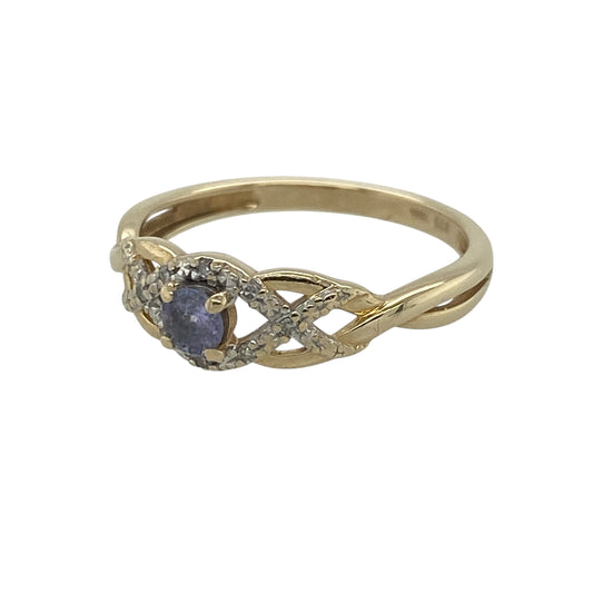 Add a touch of delicate colour and sparkle to your jewellery collection with this pre-owned 9ct yellow gold diamond and purple stone twist ring. Featuring an elegant twist design, a beautiful lavender-coloured centre stone, and sparkling diamond accents, this charming ring offers timeless femininity and style.
Design: The ring showcases a graceful twist setting centred around a round purple lavender-coloured stone measuring approximately 4mm in diameter.