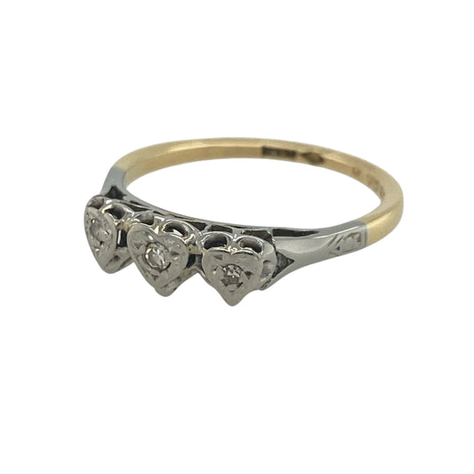 Celebrate love and elegance with this pre-owned 18ct yellow and white gold diamond heart trilogy ring. Featuring three beautifully crafted heart motifs set with sparkling diamonds, this charming two-tone ring combines meaningful symbolism with timeless style.
Design: The ring showcases a trilogy arrangement of three white gold heart-shaped settings across the front, each adorned with a small brilliant-cut diamond at its centre.