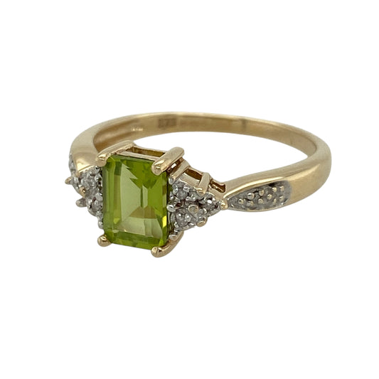 Add vibrant colour and elegant sparkle to your jewellery collection with this pre-owned 9ct yellow gold diamond and peridot ring, featuring a striking rectangular peridot stone and decorative diamond detailing—perfect as a gemstone dress ring, birthday gift, anniversary present, or colourful everyday piece.
Design: The ring features a rectangular peridot stone at the centre, complemented by diamond detailing on either side and along the shoulders of the band for an elegant and sparkling finish.