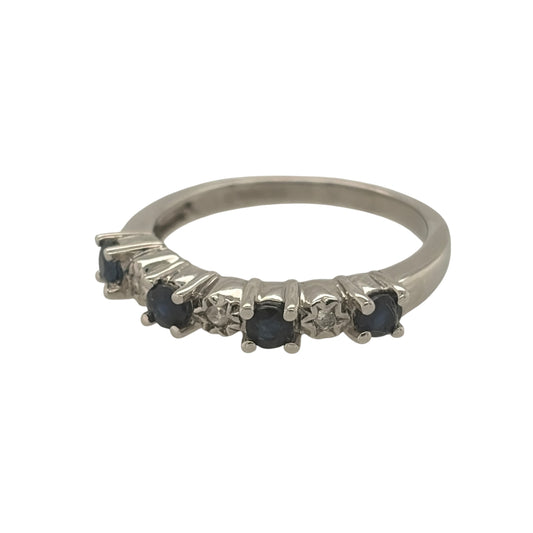 This pre-owned 9ct white gold diamond and sapphire band ring is a classic gemstone design, featuring four round sapphires complemented by diamond detailing.
Design: Featuring a traditional gemstone band design, this ring has four round sapphires arranged across the front with diamond detailing in 9ct white gold.
Material: Made from 9-carat white gold.
Gemstone Detail: Set with four round sapphires measuring approximately 3mm in diameter each, complemented by diamond detailing.