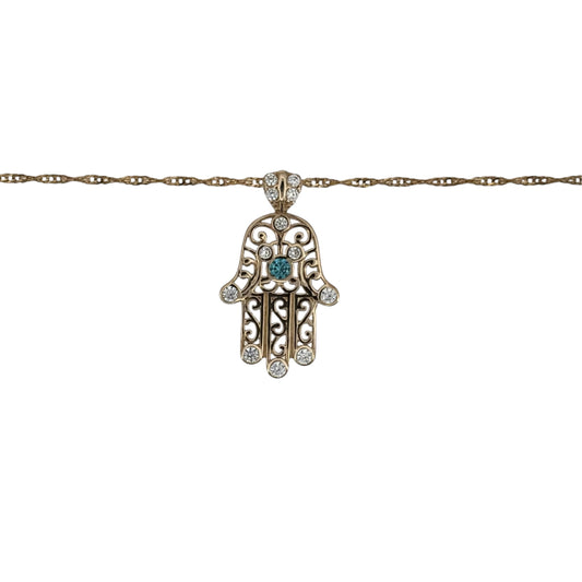 This pre-owned 9ct yellow gold cubic zirconia and blue stone set Hamsa Hand pendant necklace is a symbolic design, featuring colourful stone detailing on a delicate Singapore chain.
Design: Featuring a traditional Hamsa Hand motif, this pendant is decorated with cubic zirconia and blue stone detailing and finished in warm 9ct yellow gold.
Material: Made from 9-carat yellow gold.
Gemstone Detail: Set with cubic zirconia and blue stones within the Hamsa Hand design.