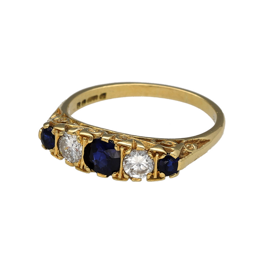 Embrace timeless charm with this pre-owned 18ct yellow gold diamond and sapphire set vintage style ring—an elegant statement piece inspired by classic design.
Design: The ring features a striking 5mm diameter round sapphire at the centre, showcasing rich blue tones and beautiful depth of colour. Surrounding diamond accents enhance the sapphire, adding refined sparkle and creating a balanced vintage-inspired silhouette.