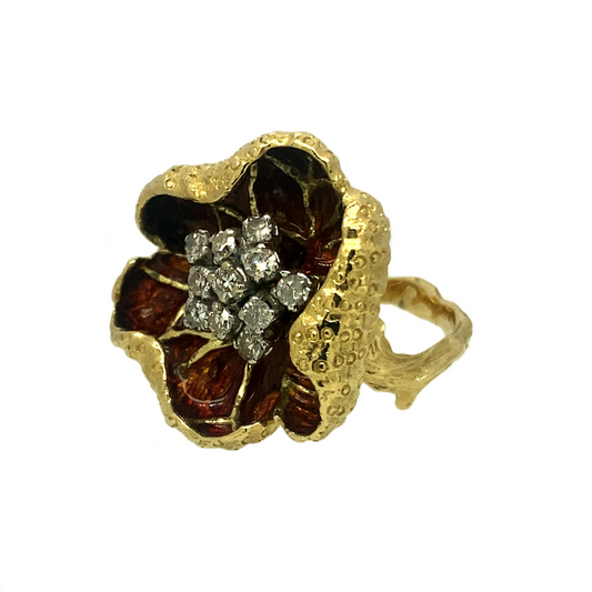 A very unique take on the popular flower ring, with the mount itself forming petals which curl around the central 'nectar' of the flower, which in turn is composed of eleven old cut Diamonds. The petals are made an even more fascinating feature of this ring by the Amber enamel set on the inside, giving it a red tint.