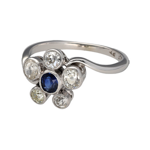 Preowned 18ct White Gold & Platinum Diamond & Sapphire Set Flower Ring in size N with the weight 3.50 grams. The Diamond are in a rubover setting in a beautiful unique Diamond & Sapphire flower dress ring. There are five old cut Diamonds ranging from approximately 5pt - 11pt - 25pt each as there are all slightly different sizes. 