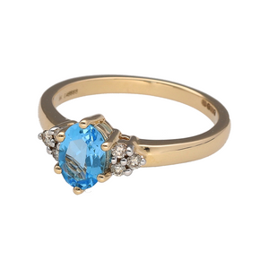 Bring vibrant colour and refined sparkle to your collection with this new 9ct yellow gold diamond and blue topaz set ring, offering a stunning blend of classic elegance and luxurious detail—perfect for adding a statement touch to any look.

Design: The ring features a striking oval blue topaz stone measuring 7mm by 5mm at the centre, accented by three small diamonds on each side, with approximately 0.11ct of total diamond content, creating a bright and captivating focal point.
