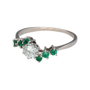 Preowned 18ct White Gold Diamond & Emerald Coloured Stones set in a Cluster Dress Ring in size Q with the weight 2.50 grams. The emerald coloured stones are each approximately 1.5mm diameter. The brilliant cut diamond is approximately 46pt - 50pt with approximate clarity Si1 - VS2 and colour K - M