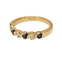 Load image into Gallery viewer, Preowned 18ct Yellow Gold Diamond &amp; Sapphire Set Band Ring in size L with the weight 3 grams. The ring is made up of three brilliant cut diamonds and four round cut sapphires set in a wave style band. There is approximately 12pt - 15pt of diamond content and the sapphire stones are each 2mm diameter 
