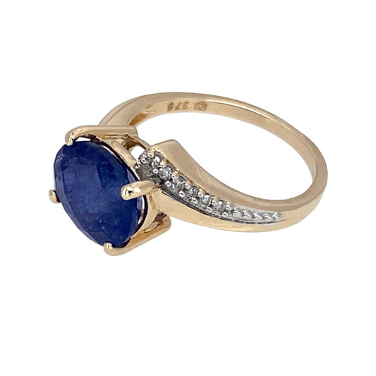 Preowned 9ct Yellow and White Gold Diamond & Blue Stone Wrap Around Ring in size J with the weight 2.60 grams. The blue stone is 9mm by 7mm