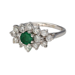 Preowned 18ct White Gold Diamond & Emerald Set Cluster Ring in size K with the weight 4.90 grams. The emerald stone is 5mm diameter and there is approximately 94pt - 1ct of diamond content set in the cluster. The diamonds are approximate clarity Si1 and colour K - M