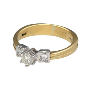 Preowned 18ct Yellow and White Gold & Diamond Set Solitaire Ring with two princess cut diamonds on either side of the center stone. The ring is in size N with the weight 4.50 grams. There is approximately 41pt of diamond content in total at approximate clarity VS2 and colour K - M