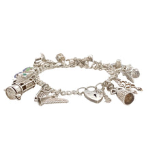 Load image into Gallery viewer, Preowned 925 Silver Welsh Themed 7&quot; Charm Bracelet with the weight 47.70 grams and link width 5mm. The bracelet has a total of 16 charms many of which have a Welsh/Irish theme. The charms are two harps, miners lamp, Irish flag crest, Welsh flag crest, three feather symbol, toadstool/fairy, crown, building, Welsh Dragon, cow, Welsh hat, pixie, fish, double lovespoon and a Welsh lady.
