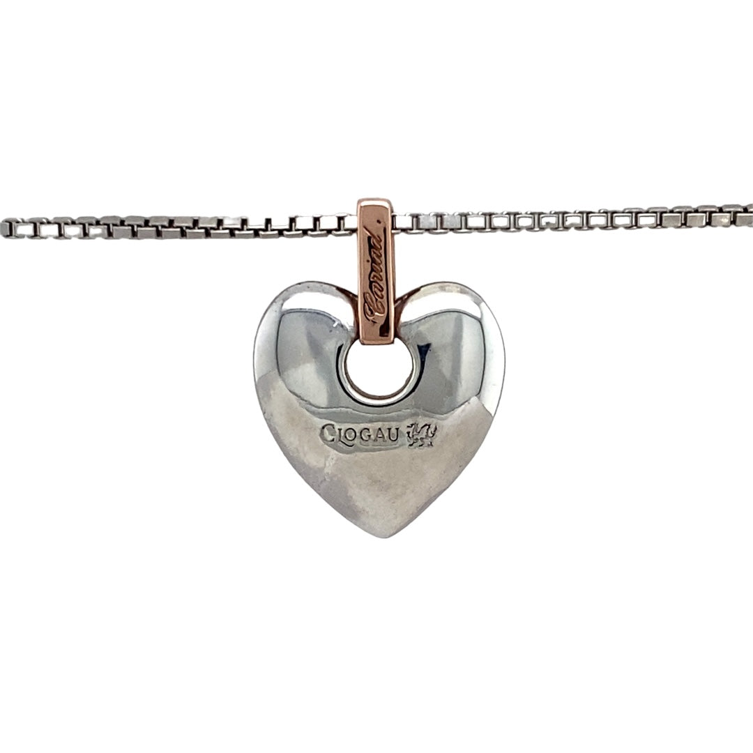 Bring heartfelt sentiment and elegant detail to your collection with this pre-owned 925 silver with 9ct rose gold Clogau Cariad heart pendant on an 18" Clogau box chain, symbolising love and affection—perfect for meaningful gifting or everyday romance.

Design: The pendant features a polished heart design with a warm 9ct rose gold accent and the word Cariad (Welsh for “beloved”) engraved within. A single diamond is set in the bail, adding a subtle touch of sparkle.