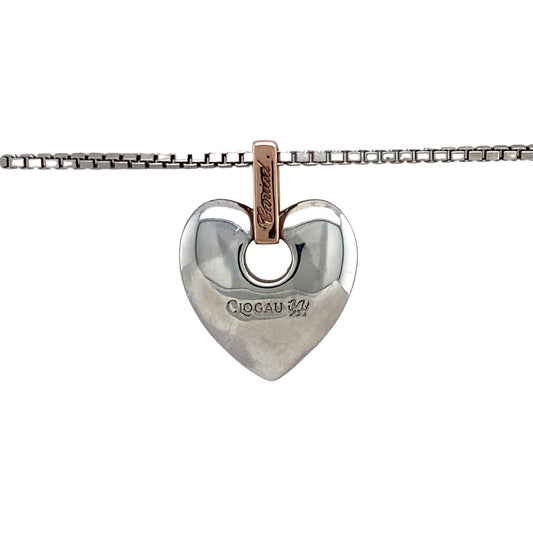 Bring heartfelt sentiment and elegant detail to your collection with this pre-owned 925 silver with 9ct rose gold Clogau Cariad heart pendant on an 18" Clogau box chain, symbolising love and affection—perfect for meaningful gifting or everyday romance.

Design: The pendant features a polished heart design with a warm 9ct rose gold accent and the word Cariad (Welsh for “beloved”) engraved within. A single diamond is set in the bail, adding a subtle touch of sparkle.