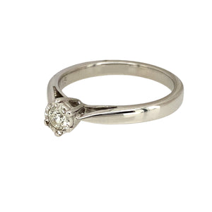 Preowned 9ct White Gold & Diamond Illusion Set Solitaire Ring in size Q with the weight 3.50 grams. The diamond is approximately 15pt with approximate clarity Si and colour K - M