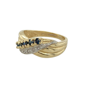 Add graceful movement and sparkle to your jewellery collection with this pre-owned 9ct yellow gold diamond and sapphire twist crossover ring, featuring:

Design: A stylish crossover band with a gentle twist, symbolising unity and flow, accented by sapphire and diamond set shoulders.
Material: 9-carat yellow gold, offering a warm and timeless polished finish.
Gemstone Detail: Set with deep blue sapphires and shimmering diamonds along the twist, creating a sophisticated contrast.
