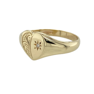Add a touch of charm and sparkle to your collection with this pre-owned 9ct yellow gold diamond set heart signet ring—sweetly styled with meaningful detail.

Design: The ring features a 9mm high heart-shaped face with delicate patterning and a single diamond accent, adding subtle brilliance to its romantic design.
Material: Made from 9-carat yellow gold, the polished finish enhances the intricate detailing and gives the piece a warm, elegant glow.
