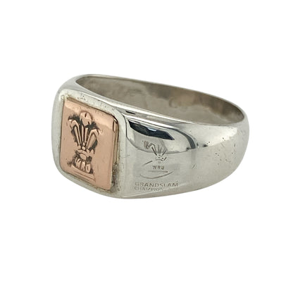 Bring national pride and bold heritage style to your jewellery collection with this pre-owned 925 silver Clogau WRU signet ring, featuring the iconic Three Feathers in 9ct rose gold—perfect for celebrating Welsh identity with timeless presence.

Design: The ring features an square-shaped front measuring 10mm high, engraved with the official WRU Three Feathers emblem in polished 9ct rose gold for a striking and recognisable finish.
