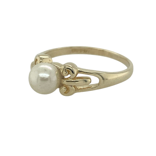 Bring timeless elegance and delicate charm to your collection with this pre-owned 9ct yellow gold pearl ring—a refined design with graceful detail.

Design: The ring features a 6mm round pearl at the centre, enhanced by floral detailing on the shoulders for a romantic touch.
Material: Made from 9-carat yellow gold, the polished finish enhances the soft lustre of the pearl and the intricate shoulder design.
