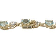 Load image into Gallery viewer, Bring vibrant colour and refined sparkle to your collection with this pre-owned 9ct yellow gold diamond and blue topaz bracelet—a timeless design with elegant character.

Design: The bracelet features a row of oval blue topaz stones, each measuring 5mm by 4mm, interspersed with diamond accents for added brilliance.
Material: Made from 9-carat yellow gold, the polished finish enhances the vivid blue tones of the topaz and the sparkle of the diamonds.

