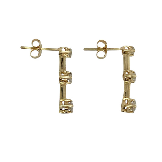 Bring subtle sparkle and modern elegance to your collection with these pre-owned 14ct yellow gold diamond bar stud earrings, a versatile design perfect for day or evening wear.

Design: Each stud features a sleek bar design, set with three sparkling diamonds that create a refined and contemporary look.
Material: Made in 14-carat yellow gold, the polished finish provides a warm glow that enhances the brilliance of the diamonds.