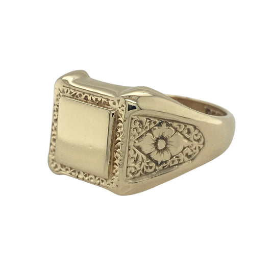 Bring bold style and detailed design to your collection with this pre-owned 9ct yellow gold square signet ring, featuring patterned shoulders and surround for a distinctive finish.

Design: The ring features a 14mm high square-shaped front with decorative surround and shoulders, adding texture and character to a traditional signet profile.
Material: Made from 9-carat yellow gold, the polished finish enhances the detailing while giving the piece a warm and refined glow.