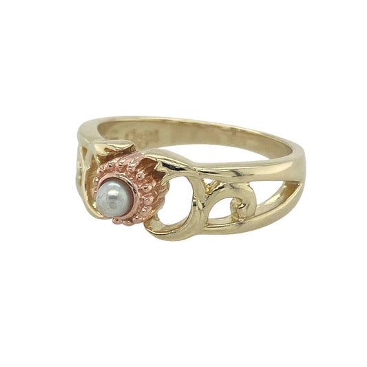 Bring natural elegance and timeless charm to your collection with this pre-owned Clogau flower-style ring in 9ct yellow and rose gold, set with a delicate pearl for a graceful finish.

Design: The ring features a flower-inspired motif centred with a 3mm round pearl, accented by yellow and rose gold detailing for a soft two-tone effect.
Material: Made from 9-carat yellow and rose gold with a cultured pearl, the polished finish enhances the warm tones and lustrous glow.