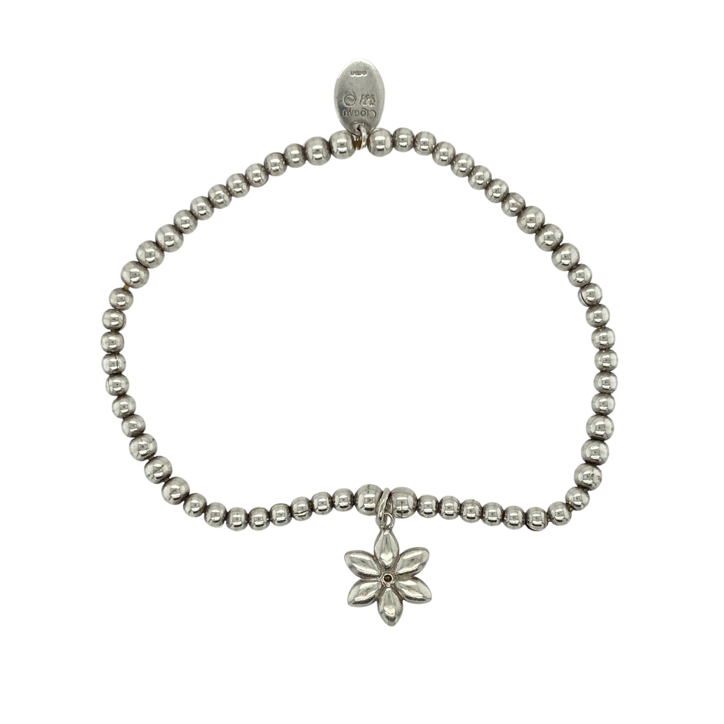 Add soft elegance and natural beauty to your collection with this pre-owned 925 silver and 9ct rose gold Clogau beaded stretchy bracelet, featuring a delicate floral charm for a touch of timeless femininity—perfect for everyday wear or gifting.

Design: The bracelet is composed of polished silver beads with a 12mm diameter flower charm set with shimmering mother of pearl, capturing a gentle iridescence that reflects the light beautifully.