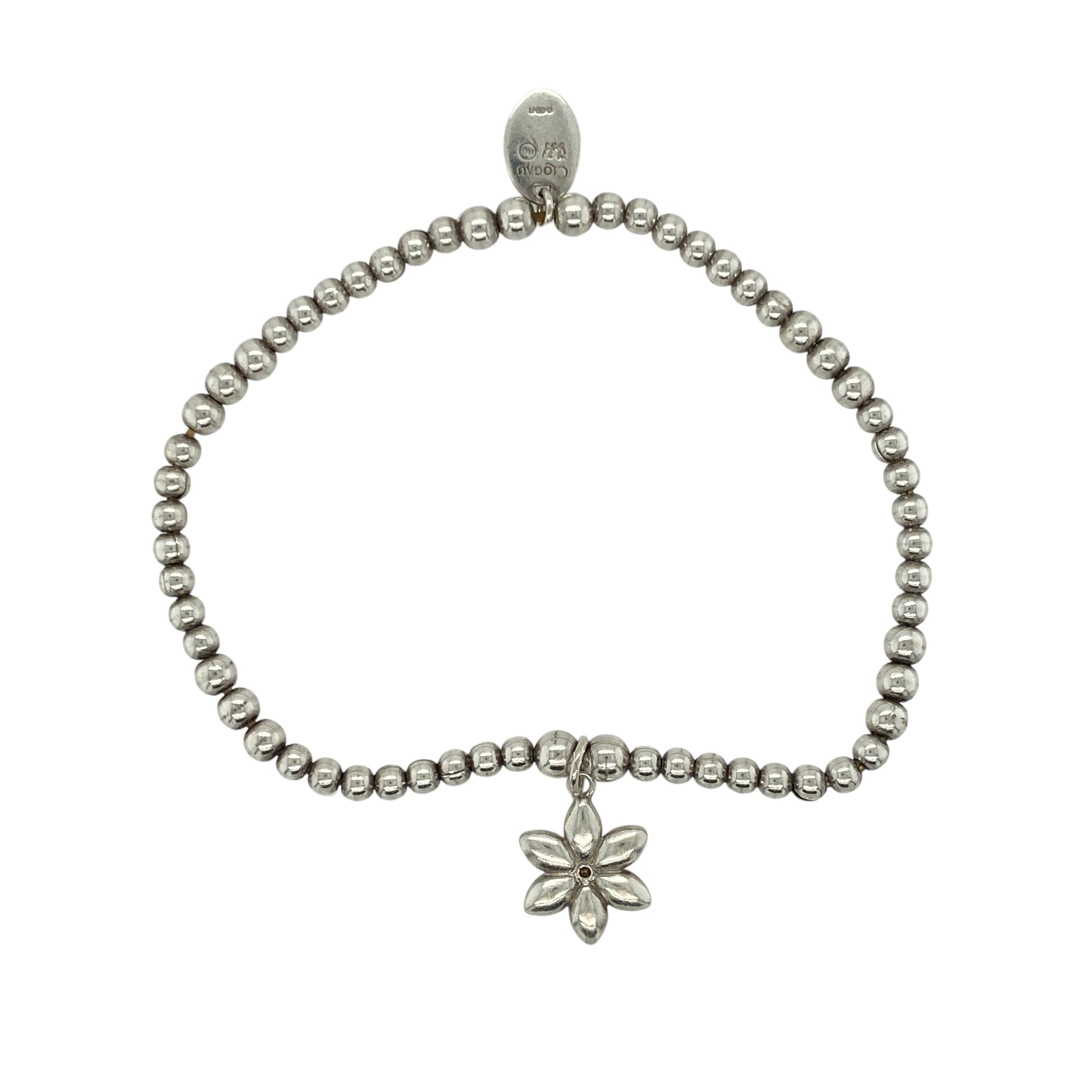 Add soft elegance and natural beauty to your collection with this pre-owned 925 silver and 9ct rose gold Clogau beaded stretchy bracelet, featuring a delicate floral charm for a touch of timeless femininity—perfect for everyday wear or gifting.

Design: The bracelet is composed of polished silver beads with a 12mm diameter flower charm set with shimmering mother of pearl, capturing a gentle iridescence that reflects the light beautifully.