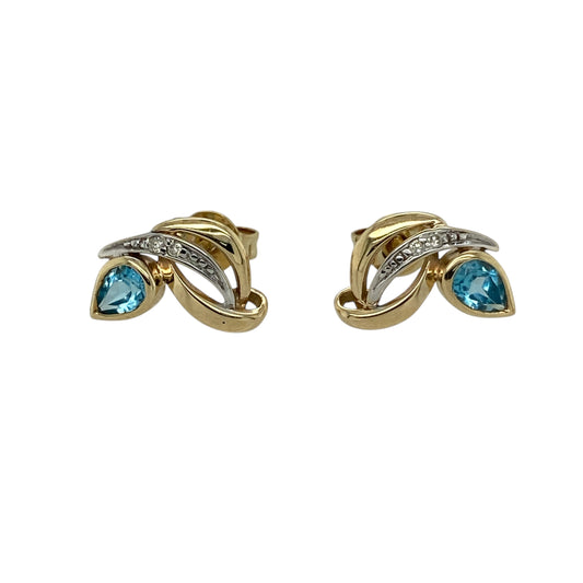Bring delicate colour and refined sparkle to your jewellery collection with these pre-owned 9ct yellow gold diamond & blue topaz set stud earrings, a graceful design with timeless appeal.

Design: Each stud features a teardrop-shaped blue topaz measuring 4mm by 2mm, accented with diamonds that add subtle brilliance and enhance the elegant silhouette.
Material: Made from polished 9-carat yellow gold, the warm tone beautifully complements the cool blue of the topaz and the sparkle of the diamonds.