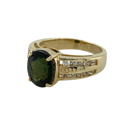 Bring rich colour and elegant contrast to your jewellery collection with this pre-owned 9ct yellow gold green tourmaline and white topaz set ring.

Design: The ring features an oval green tourmaline at the centre, measuring approximately 10mm by 8mm, complemented by sparkling white topaz accents that enhance its vibrant green hue.
Material: Made from 9-carat yellow gold, the warm polished finish beautifully balances the vivid colour of the tourmaline and the brilliance of the white topaz.