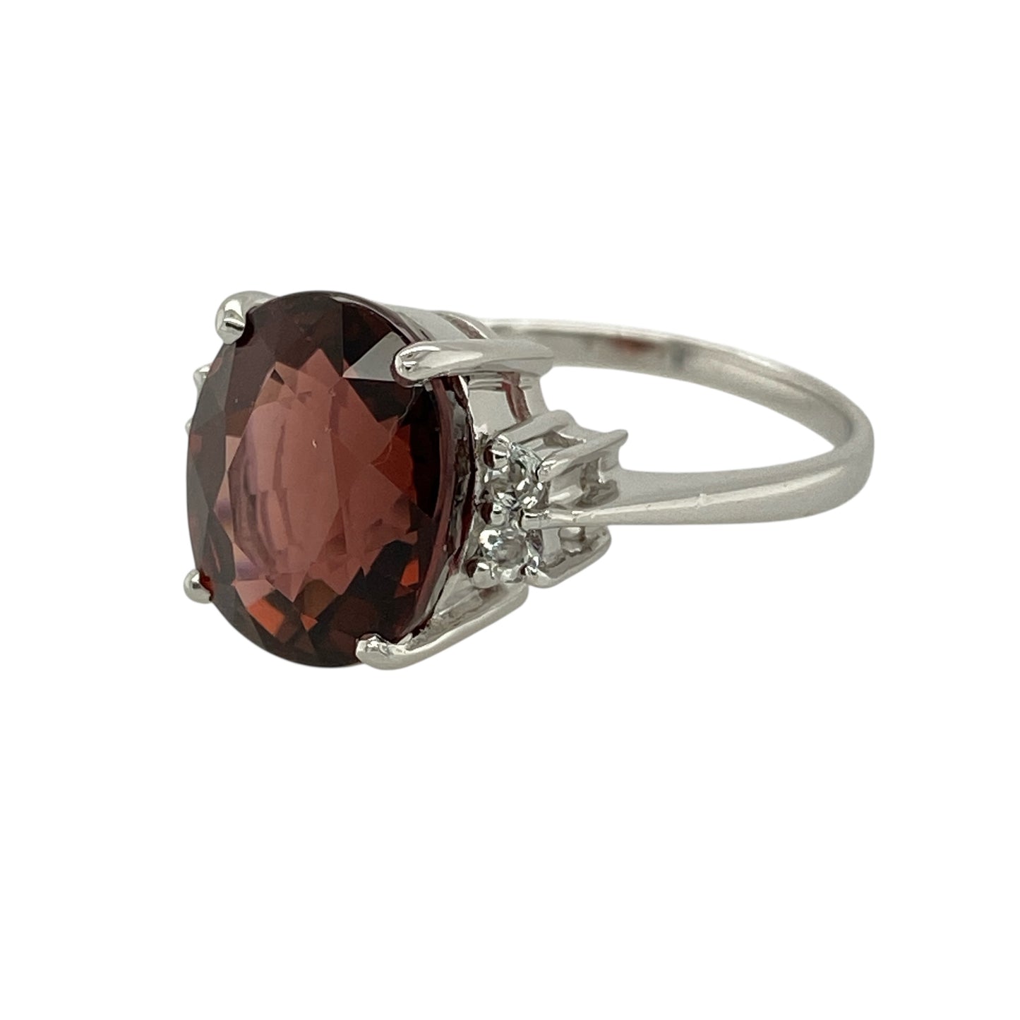 Bring warm colour and refined sparkle to your jewellery collection with this pre-owned 9ct white gold apricot tourmaline and white topaz set ring.

Design: The ring features an oval apricot tourmaline at the centre, measuring approximately 12mm by 10mm, creating a soft yet striking focal point, with white topaz stones set along the shoulders for added brilliance.