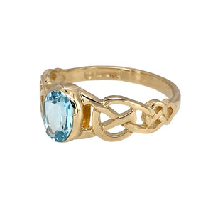 Preowned 9ct Yellow Gold & Blue Topaz Set Celtic Knot Ring in size N with the weight 2.40 grams. The blue topaz stone is 7mm by 5mm