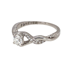 Preowned 18ct White Gold & Diamond Halo Solitaire Ring with diamond set crossover shoulders. The ring is in size M with the weight 2.80 grams. There is approximately 40pt of diamond content set in total with approximate clarity i2 and colour K - M