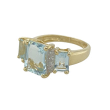 Load image into Gallery viewer, Add a touch of elegance to your jewellery collection with this pre-owned 9ct yellow gold diamond and aquamarine set ring.

Design: Featuring a striking design, this ring showcases a beautiful center aquamarine stone flanked by two smaller aquamarine stones, with diamonds adding a touch of sparkle to the overall design.
Material: Made from 9-carat yellow gold, offering a warm and polished finish that complements the cool blue tones of the aquamarine.
Gemstone Detail: The center aquamarine measures 9mm by 7mm
