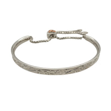 Load image into Gallery viewer, Add a touch of sophistication and luxury to your jewellery collection with this pre-owned 925 silver with 9ct rose gold and diamond-set Clogau patterned bangle.

Design: This bangle features intricate Clogau patterned detailing, paired with the warmth of 9ct rose gold accents. The adjustable heart clasp adds a unique and stylish feature, with two small diamonds set inside for added sparkle.
Material: Crafted from 925 silver with 9ct rose gold, this bangle offers a beautiful combination of traditional crafts
