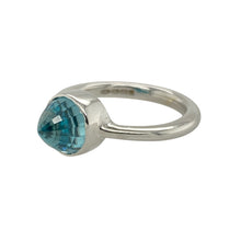 Load image into Gallery viewer, Make a striking statement with this pre-owned 9ct white gold and blue stone set dress ring, combining cool tones with dramatic shape for a standout look, featuring:

Design: A modern dress ring centred around a bold blue crystal-cut stone with a pointed, outward-facing dome, offering an eye-catching and sculptural silhouette.
Material: Made from 9-carat white gold, the sleek, polished finish enhances the vibrant blue tones and gives the ring a clean, contemporary edge.

