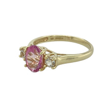 Load image into Gallery viewer, Add a touch of feminine sparkle to your collection with this pre-owned 9ct yellow gold pink and white cubic zirconia set trilogy ring, blending soft colour with timeless design, featuring:

Design: A classic trilogy style symbolising the past, present, and future, with a pink oval-cut centre stone flanked by two sparkling white stones for graceful contrast.
Material: Made from 9-carat yellow gold, the polished finish enhances the warm tone of the setting and the brilliance of the stones.

