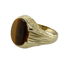 Load image into Gallery viewer, Add strength and natural style to your collection with this pre-owned 9ct yellow gold Tiger’s Eye signet ring, combining classic form with the earthy elegance of a striking gemstone, featuring:

Design: A bold signet style ring showcasing a large oval Tiger’s Eye stone, known for its rich golden-brown tones and natural chatoyancy, offering both presence and personality.
Material: Made from 9-carat yellow gold, the smooth, polished finish complements the warm hues and shifting bands of the Tiger’s Eye.
