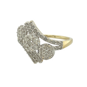 Add a flourish of sparkle and floral elegance to your collection with this pre-owned 9ct yellow gold diamond set triple flower cluster ring, combining graceful curves with brilliant detail, featuring:

Design: A striking triple flower cluster design, each bloom formed by a cluster of diamonds, arranged across the front of the ring on a gently twisted wrap-over band for a dynamic and flowing silhouette.
Material: Made from 9-carat yellow gold, the polished finish enhances the ring’s warm tone