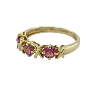 Bring romantic charm to your collection with this pre-owned 9ct yellow gold and pink stone band ring, featuring delicate design details and a soft splash of colour—perfect for gifting or everyday wear.

Design: The ring is set with three 4mm diameter pink stones, each accented with a subtle cross (kiss) shape at its centre, creating a sweet and symbolic look.
Material: Made from 9-carat yellow gold, the polished finish enhances the warmth of the gold and complements the gentle hue of the pink stones.

