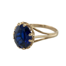 Load image into Gallery viewer, Bring rich colour and elegance to your collection with this pre-owned 9ct yellow gold and blue stone ring, offering a timeless design with a bold centrepiece—perfect for special occasions or standout everyday wear.

Design: The ring features a striking oval-cut blue sapphire-coloured stone, set in a classic four-claw setting for a refined and balanced look.
Material: Made from 9-carat yellow gold, the polished finish enhances the depth of the blue stone and adds warmth to the overall design.
