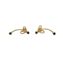 Load image into Gallery viewer, Bring sweet charm and classic colour to your collection with these pre-owned 9ct yellow gold and sapphire bow stud earrings, offering a delicate design with a touch of vintage elegance—perfect for everyday wear or thoughtful gifting.

Design: Each earring features a dainty bow style design set with 2mm round sapphires, adding a pop of rich blue colour to a timeless feminine silhouette.

