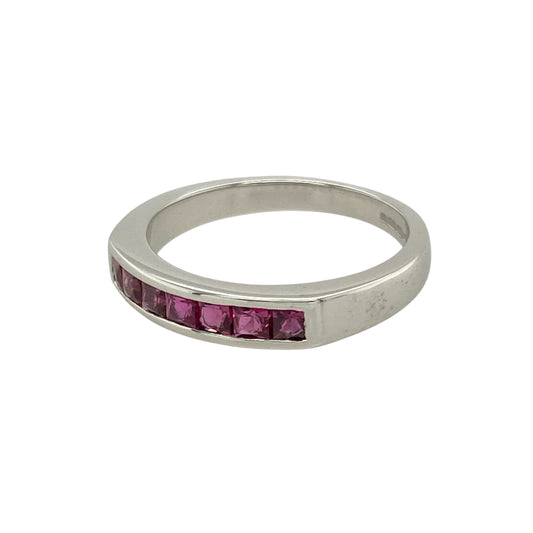 Bring refined colour and timeless elegance to your collection with this pre-owned 18ct white gold ruby set band ring, featuring a sleek design and vibrant gemstone detail—perfect for stacking, gifting, or everyday luxury.

Design: The front of the 3mm wide band is set with square-cut rubies, each measuring 2mm by 2mm, creating a clean, modern line of rich red sparkle.
