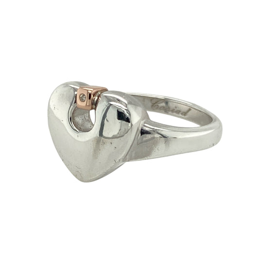 Celebrate love and Welsh heritage with this pre-owned 925 silver and 9ct rose gold Clogau diamond heart ring—a romantic and meaningful design with timeless charm.

Design: The ring features a beautifully shaped heart at the centre, measuring 11mm high, accented with delicate diamond detailing for added sparkle and elegance.
Material: Crafted from sterling silver with 9-carat rose gold highlights, the mixed-metal design offers a warm and graceful contrast that enhances the heart motif.
