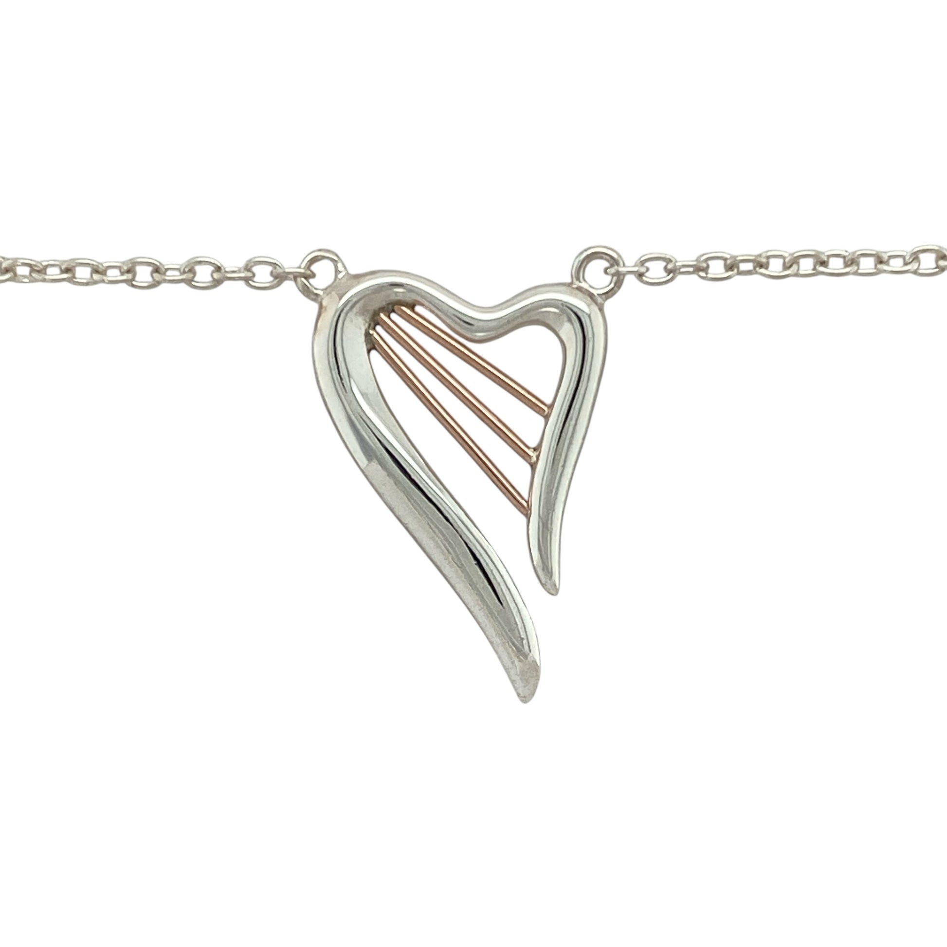 Celebrate love and harmony with this pre-owned 925 silver and 9ct rose gold Clogau Heartstrings necklace—an elegant piece inspired by music, emotion, and connection.

Design: The pendant features a beautifully shaped heart measuring 2.5cm by 1.7cm, with flowing lines reminiscent of harp strings—symbolising the music of the heart.
Material: Made from sterling silver with 9-carat rose gold accents, the mixed-metal design creates a soft contrast with timeless Clogau character.

