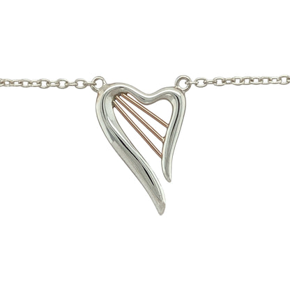 Celebrate love and harmony with this pre-owned 925 silver and 9ct rose gold Clogau Heartstrings necklace—an elegant piece inspired by music, emotion, and connection.

Design: The pendant features a beautifully shaped heart measuring 2.5cm by 1.7cm, with flowing lines reminiscent of harp strings—symbolising the music of the heart.
Material: Made from sterling silver with 9-carat rose gold accents, the mixed-metal design creates a soft contrast with timeless Clogau character.
