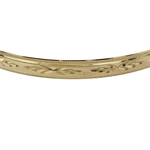 Add timeless elegance and refined detail to your collection with this pre-owned 9ct yellow solid gold patterned bangle—classic design with a bold, polished presence.

Design: This bangle features a 5mm wide band with intricate engraved patterning, offering a touch of texture and traditional charm in a sleek, rounded silhouette.
Material: Made from solid 9-carat yellow gold, the polished finish enhances the decorative detailing and provides a rich, radiant glow.
