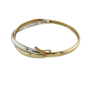Add elegant contrast and timeless design to your collection with this pre-owned 9ct yellow and white gold crossover front bangle—sleek, stylish, and beautifully balanced.

Design: This bangle features a classic crossover front with two 4mm wide bands—one in polished yellow gold and the other in white gold—creating a sophisticated two-tone look.
Material: Made from 9-carat yellow and white gold, the polished finish enhances the smooth curves and contrasting tones.
