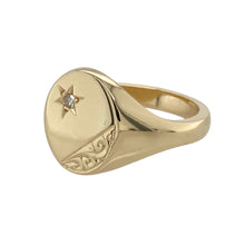 Load image into Gallery viewer, Bring refined detail and classic presence to your collection with this pre-owned 9ct yellow gold and diamond set engraved signet ring—a bold yet elegant piece with timeless character.

Design: The ring features a 14mm high oval head with fine engraving and a single diamond accent, adding a subtle touch of sparkle to the traditional signet style.
Material: Made from 9-carat yellow gold, the polished finish enhances the engraved detail and gives the ring a warm, lustrous glow.

